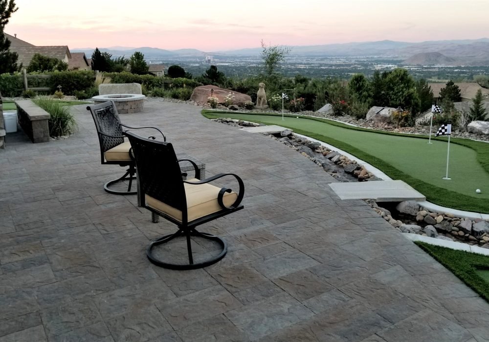 synthetic turf paver patio and dry creek in back yard with city view
