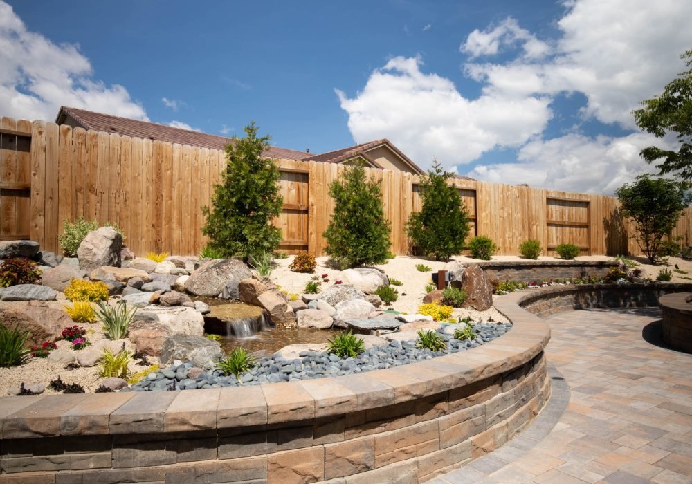 Retainer seat wall with cap and a water feature. Contact us at Gail Willey landscaping for a quote